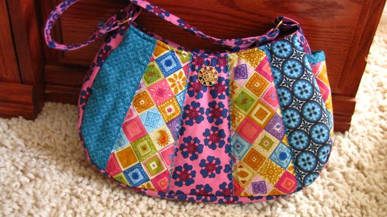 Medium size Approx. 13 X 8in. Magnetic snap, cell phone pocket, inside pockets, one handle